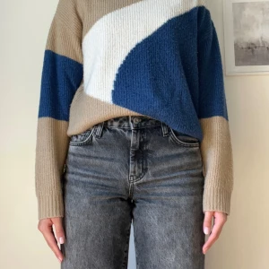 Beige och blå stickad tröja NA-KD - Stickad tröja från NA-KD i beige, blått och vitt med coolt grafiskt mönster. Tröjan har hög krage, lång ärm och relaxed fit. Supermjuk tröja perfekt till vinter och höst.