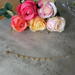 Guldarmband med berlocker från Rosefield - Snyggt guldarmband från Rosefield med små runda berlocker längs hela kedjan. Armbandet har en tunn kedja och stängs med ett klassiskt lås. Perfekt accessoar för att lyfta din outfit med en trendig touch.