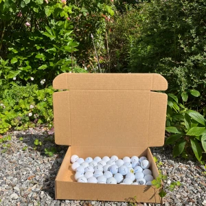 Srixon Golfmix - Bilderna visar en öppen kartong fylld med golfbollar av märket Srixon. Bollarna är A-klass. 50-pack.