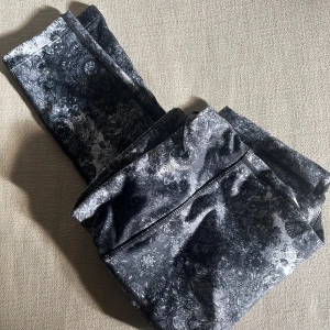 Svarta och vita leggings från KappAhl - Snygga leggings från KappAhl i svartvitt mönster med detaljerad spetsinspirerad print. Mjukt och stretchigt material med borstad insida som känns riktigt skönt mot huden. Perfekta för dig som vill ha något bekvämt men ändå stilrent. Smått fodrade. 