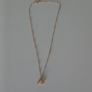 Guldigt halsband med planet-hänge - Guldigt halsband med ett planet-hänge. Används inte längre. 