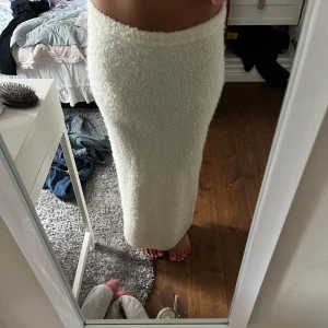 Vit lång stickad kjol - Mysig vit långkjol i stickat material med fluffig känsla. Kjolen har en rak passform. Perfekt för dig som gillar en enkel men ändå trendig look. Jätte mysigt nu till sen sommar och höst🍂. Knappt använd också