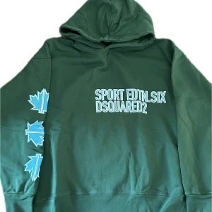 Dsquared2 hoodie  - Exklusiv mörkgrön hoodie från Dsquared2 – en perfekt mix av streetwear och premiumkvalitet. Tillverkad i mjuk bomull med snygga detaljer och ikonisk Dsquared2-logga. Perfekt för en avslappnad men stilren look, oavsett om du matchar med jeans eller joggers. Välvårdad, inga fläckar eller skador. Skicka PM vid intresse! 