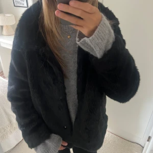 Svart ”fejk” pälsjacka  - En snygg svart ”fejk” pälsjacka. Använd en hel del, därav små defekter som exempelvis knapparna framtill har lossnat. Jackan går fortfarande att använda🩷