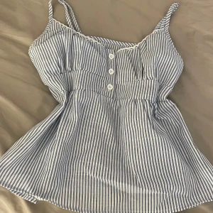 Sommartopp - Blårandig, söt sommartopp som passar till både kjol och byxor. Tröjan är helt ny, men säljer pga att den inte har kommit till användning.