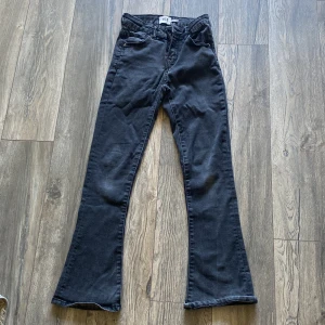 Svarta bootcut jeans från 157, stl 150 - Svarta jeans från 157 i storlek 150. Modellen har bootcut-ben och klassisk femficksdesign. Jeansen är tillverkade i ett mjukt bomullstyg med lite stretch för extra komfort. Perfekta för dig som gillar en tidlös look med lite utsvängda ben.