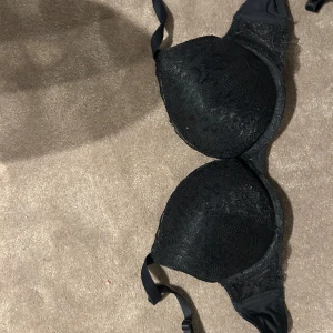 2 spetsiga push-up bh:ar svart & svart/vit - Säljer två push-up bh:ar, en helsvart med spetsdetaljer och en svart med vit spets och blommönster. Båda har vadderade kupor och justerbara axelband. Perfekt för dig som gillar snygga och feminina underkläder med extra lyft.