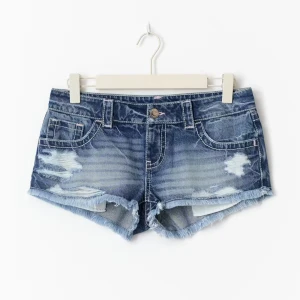 Lågmidjade jeansshorts med slitningar - Snygga blå jeansshorts med låg midja och fransig kant. Shortsen har slitna detaljer framtill och bakfickor med dekorativa sömmar. Perfekta för sommaren och ger en cool, avslappnad vibe. Klassisk femficksmodell i mjuk denim.  Skriv till mig om ni vill ha fler bilder!💗💗
