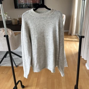 Ljusgrå stickad tröja från Solid - Enkel och stilren ljusgrå stickad tröja från Solid. Tröjan har rund halsringning, ribbade muddar och är långärmad. Perfekt för lager-på-lager och passar till allt. Skön och mjuk känsla tack vare det stickade materialet.