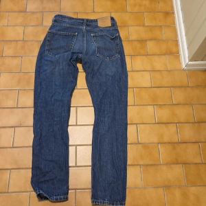 Blåa relaxed jeans Jack & Jones 27/32 - Snygga blå jeans från Jack & Jones i modellen Relaxed/Chris. De har en avslappnad passform med raka ben och klassiska bakfickor. Jeansen är gjorda i slitstarkt denim med kontrastsömmar och passar perfekt för en chill och stilren look.