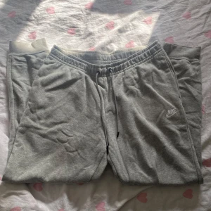 Grå Nike mjukisbyxor  - Gråa mjukisbyxor från Nike storlek L. Dom är aldrig använda och är i ett super skick, skriv vid fler bilder eller frågor🩶