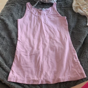 Ljusrosa linnetopp från Heart Your - Säljer en enkel och snygg ljusrosa linnetopp från Heart Your. Toppen är ärmlös med rund halsringning och tillverkad i mjuk bomull. Perfekt att matcha med jeans eller shorts för en chill look.