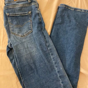 Blå jeans från Vero Moda - Snygga blå jeans från Vero Moda med klassisk femficksdesign och dragkedja. Jeansen är mid waist 
