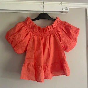 Korallfärgad offshoulder blus - Superfin korallfärgad blus med offshoulder och puffiga korta ärmar.  