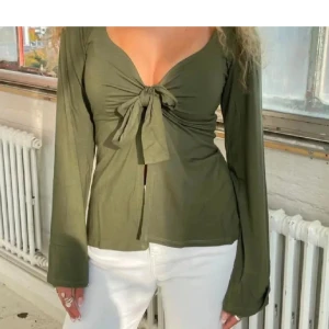 Designbysi mörkgrön topp🍓🫶🏼🙈 - Snygg olivgrön topp med långa ärmar och knyt framtill. Toppen har en djup v-ringning och en figurnära passform som framhäver midjan. Den är verkligen så skön att bara ha hemma en slapp dag, men jag har tyvärr tröttnat på den!🙌🏼😍🍓