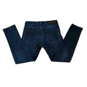 Mörkblå Replay Jeans - Snygga mörkblå jeans från Replay i modellen Anbass. De har en klassisk femficksdesign med knapp och dragkedja framtill. Perfekta för en stilren look. Dem är i modellen Anbass Hyperflex som är slim fit😇Kom gärna med frågor och prisförslag👖Först till kvarn‼️