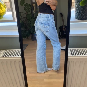Ljusblå jeans med bootcut - Snygga ljusblå jeans med bootcut-stil och klassisk femficksdesign. Jeansen har en dragkedja och två knappar framtill💕