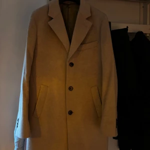 Beige rock - Snygg beige rock från John Henric med klassisk design och tre knappar framtill. Storlek 48 använd fåtal gånger så den är som helt ny. Köpt för 3800kr.