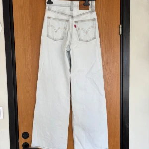 Ljusa jeans från Levi's - Säljer ett par ljusa Levi's jeans med klassisk design och femficksmodell. De har en hög midja och är baggy, vilket ger en tidlös look. Perfekta för en avslappnad stil. Pris kan diskuteras.