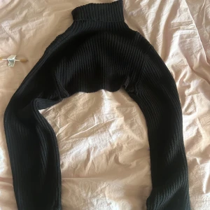 Svart ribbad polotröja - Säljer en stilren svart ribbad polo bolero med långa ärmar. Hör av dig vid intresse!