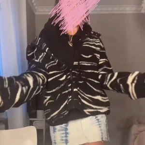 Svart och vit teddyjacka!! - Säljer en cool svart och vit mönstrad jacka med dragkedja. Jackan har ett zebramönster och är långärmad, perfekt för att sticka ut i mängden. Den har en normal passform och är idealisk för höst och vår.