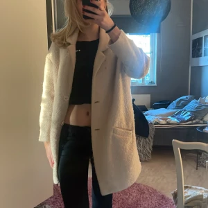 Beige kappa - Säljer en stilren beige kappa med knappar framtill. Jackan har en klassisk design med långa ärmar och två fickor. Skriv för mer bilder 🩷