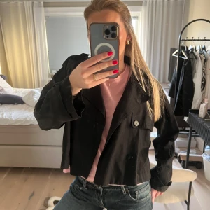 Svart trenchcoat  - Snygg svart kort trenchcoat, SLUTSÅLD från Carin Wester! Perfekt nu till våren. Mycket fint skick! Nypris: 1000kr