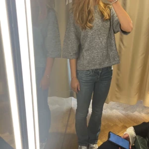 Grå tröja med trekvartsärm - Säljer en stilren grå tröja med trekvartsärm. Perfekt för en avslappnad look. Tröjan har en lös passform och är tillverkad i ett mjukt material.