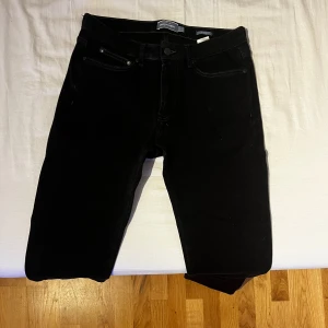 Svarta jeansbyxor - Snygga svarta jeansbyxor med en klassisk design. De har en slim fit passform och är tillverkade i ett slitstarkt system material. Perfekta för en stilren look.Storlek 32/32