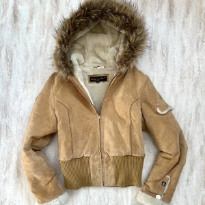 Babyphat jacka  - Babyphat tan & brun mockajacka, ribbad midja, pälsfodrad huva och babyphat-logga i ryggen, storlek M! Provdockan är en storlek S som referens 💕 har fläckar exempel är bild 5, katt berlocken till dragkedjan har också gått av, skriv för mer bilder på defekterna!!! 🫶🏻 