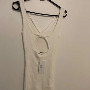 Klänning från chiquelle med fina detaljer i ryggen - Vit ribbad klänning med fin rygg. Aldrig använd och lappen kvar. Onesize för den ar så strechig men ca s-m