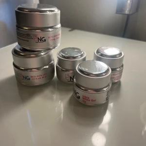 Builder Gel och Top Gel från NG - Säljer flera burkar av NG Builder Gel och Top Gel. Inkluderar Builder Gel i färgerna Pink och Clear, båda 30 gram, samt Top Gel på 15 gram. Perfekt för nagelbyggnad och finish. Samt en vit gele och en low heat builder gel! Mycket kvar i de, använda några gånger, vissa är mer i än andra. Skriv privat för mer info!! Säljs då jag slutat med naglar! 💗