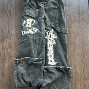 Svarta Y2k jeans med tryck - Snygga svarta jeans med coola tryck i vitt.  Perfekta för en streetwear-look.