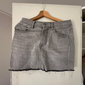 Grå jeanskjol från Lager 157 - Snygg grå jeanskjol med rå kant och klassisk femficksdesign. Perfekt för en avslappnad stil. 