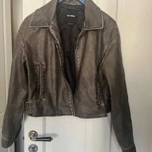Brun skinnjacka från Pull&Bear - Snygg brun skinnjacka från Pull&Bear med dragkedja framtill. Jackan är i storlek L men passar perfekt för S/M. 😍😍Jackan har en croppad passform och långa ärmar. Perfekt för en tuff och avslappnad stil.  Går såklart att pruta!