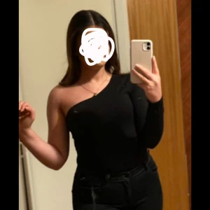 Svart oneshoulder bodysuit - Snygg svart oneshoulder bodysuit med lång ärm. Gillar den men tyvärr så har den blivit liten i storleken på mig..💖