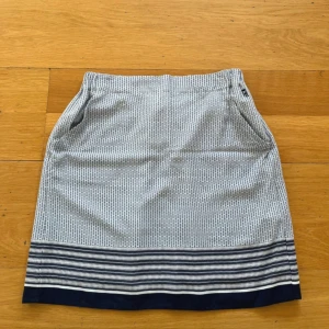 Blåvit mönstrad kjol från Henri Iloyd - Säljer en blåvit Colette Printed Skirt från Henri IIoyd, i storlek XS. Kjolen har diskret geometriskt mönster och breda horisontella ränder längst ner. Den har fickor på sidorna och resår i midjan för extra komfort. Ny med prislapp! Jag är ingen kjol tjej så blivit hängade! Tunt skönt material! Vit blå och ljusblått mönster 