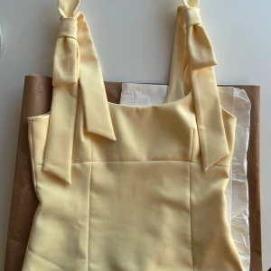 Ljusgul topp med rosettband från Zara - Supersöt populär ljusgul topp från Zara! Toppen är i storlek S. Helt slutsåld på hemsidan. Helt ny, endast provad! Lappen är kvar. Säljer då den inte passade mig💛Hör av dig vid frågor! 