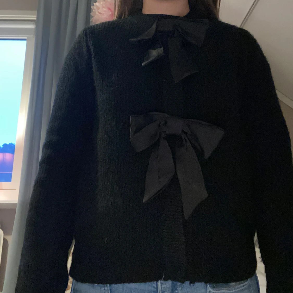 Svart kofta med rosetter