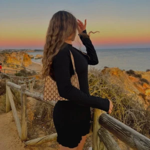 Svart ribbad långärmad kortklänning - Säljer en svart, tight ribbad klänning med lång ärm och rund hals. Klänningen är kort och har en figurnära passform. Har också en lite open back