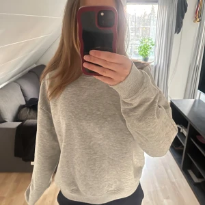 Ljusgrå sweatshirt  - En basic ljusgrå sweatshirt från lager med rund halsringning och långa ärmar. Tröjan har en avslappnad passform och ribbade muddar vid ärmslut och nederkant. Perfekt för en enkel och stilren look.