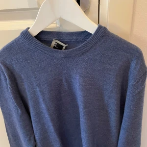 Merino tröja  - Säljer en stilren blå merino tröja i storlek S, fin tröja med få negativt förutom etiketten som sitter lite konstigt. Förutom det är den jättefin.