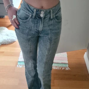 Ljusblå midwaist bootcut jeans med detalj i fram - Säljer ett par ljusblå midwaist bootcut jeans, från new yorker. Jeansen har fem fickor, dubbla knappar och tydliga sömmar framtill. Perfekta för dig som gillar en retroinspirerad look💕