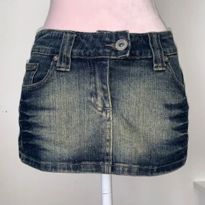 Jeanskjol - Denim minikjol. Från parisian. Ska sitta lågmidjat. Står storlek 38 men passar mer som 34. Glittrig och stretchig. 