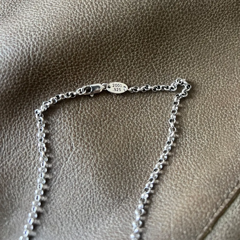 Elegance of Dual Cross Necklace Ett sofistikerat halsband med två kors i olika storlekar, hängande från en elegant 60 cm lång kedja. Det stora korset mäter 2,8 cm och det lilla 1,8 cm, vilket ger en vacker balans mellan klassisk design och modern minimalism. Perfekt för att addera en subtil men lyxig touch till varje look.. Asusteet.