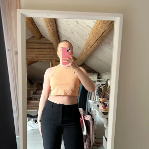 Persikofärgad croppad linnetopp från Bik Bok - Säljer en persikofärgad croppad linnetopp från Bik Bok. Toppen har ärmlös design och rund halsringning, perfekt för varma dagar. Den är köpt direkt från bik bok för några år sedan och har använts några gånger hos mig🥰