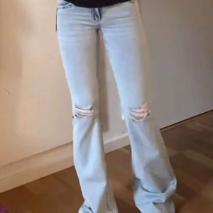  lågmidjade bootcut jeans från Nelly 32 - Snygga ljusblå bootcut jeans med slitningar på knäna och coola broderade detaljer på bakfickorna. Jättesnygga jeans från Nelly i nytt skick, endast använda en gång! Storlek 32.