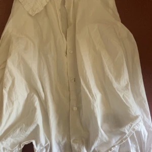 Y2k tajt vit blus  - Supersöt y2k tajt vit blus från Gina Tricot i storlek 34. Blusen har knappar framtill. Perfekt att styla med jeans eller kjol för en fräsch och iconic look.