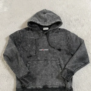 Saint Laurent Hoodie  - Säljer min Saint Laurent hoodie som är väldigt sällsynt. Toppenskickt utan defekter, hoodien har slitage men det är fel av designen.✅ Storlek XS men sitter mer som en S-M. Passar lite liten på mig som är 183. ✅