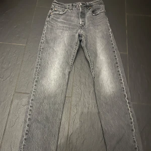Grå Levis 501 jeans - Snygga grå Levis 501 jeans med klassisk design och fem fickor. De har en knappgylf och är tillverkade i slitstarkt denim. Perfekta för en avslappnad stil.